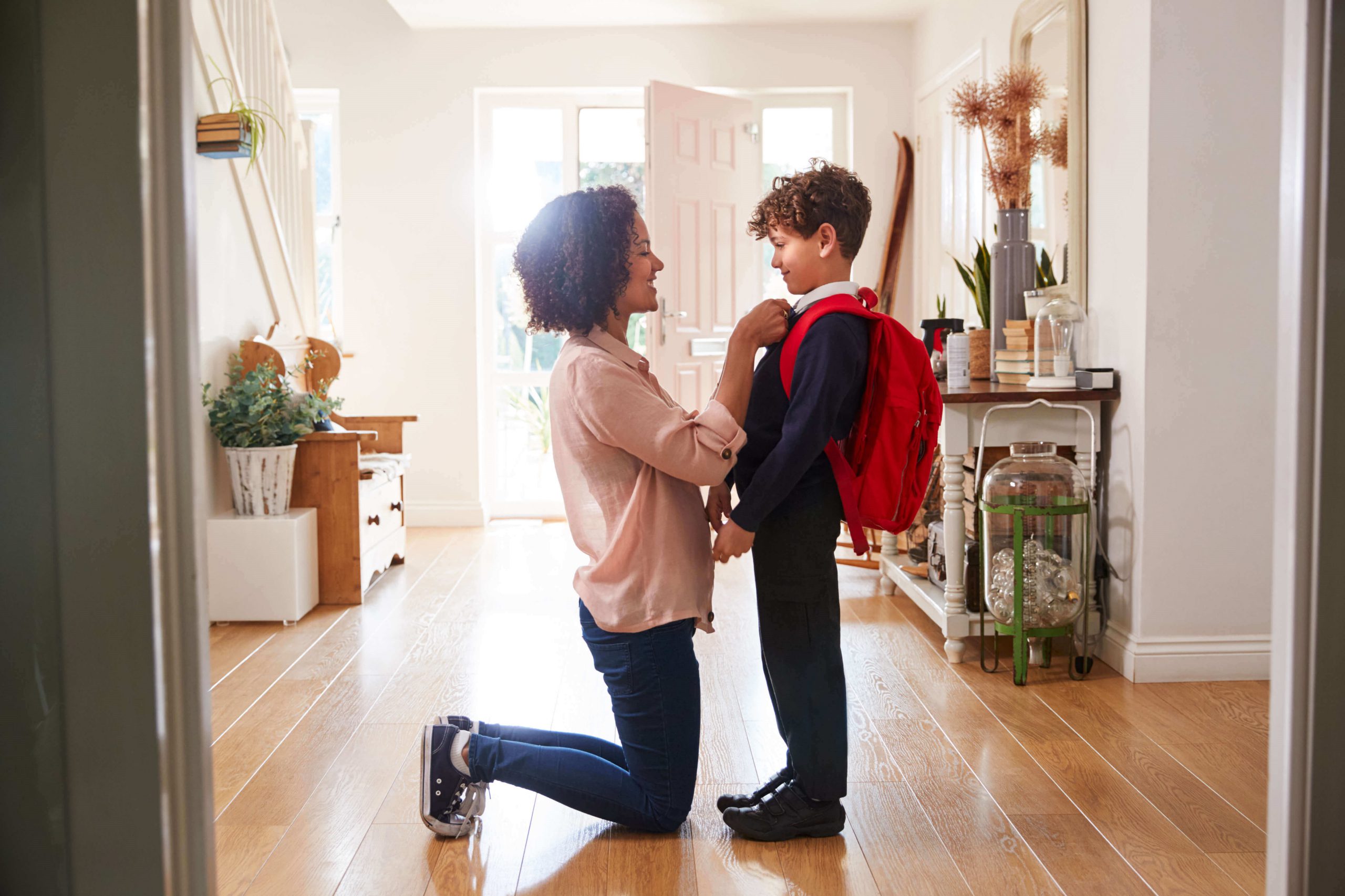 Mum helping son with school uniform before leaving for school