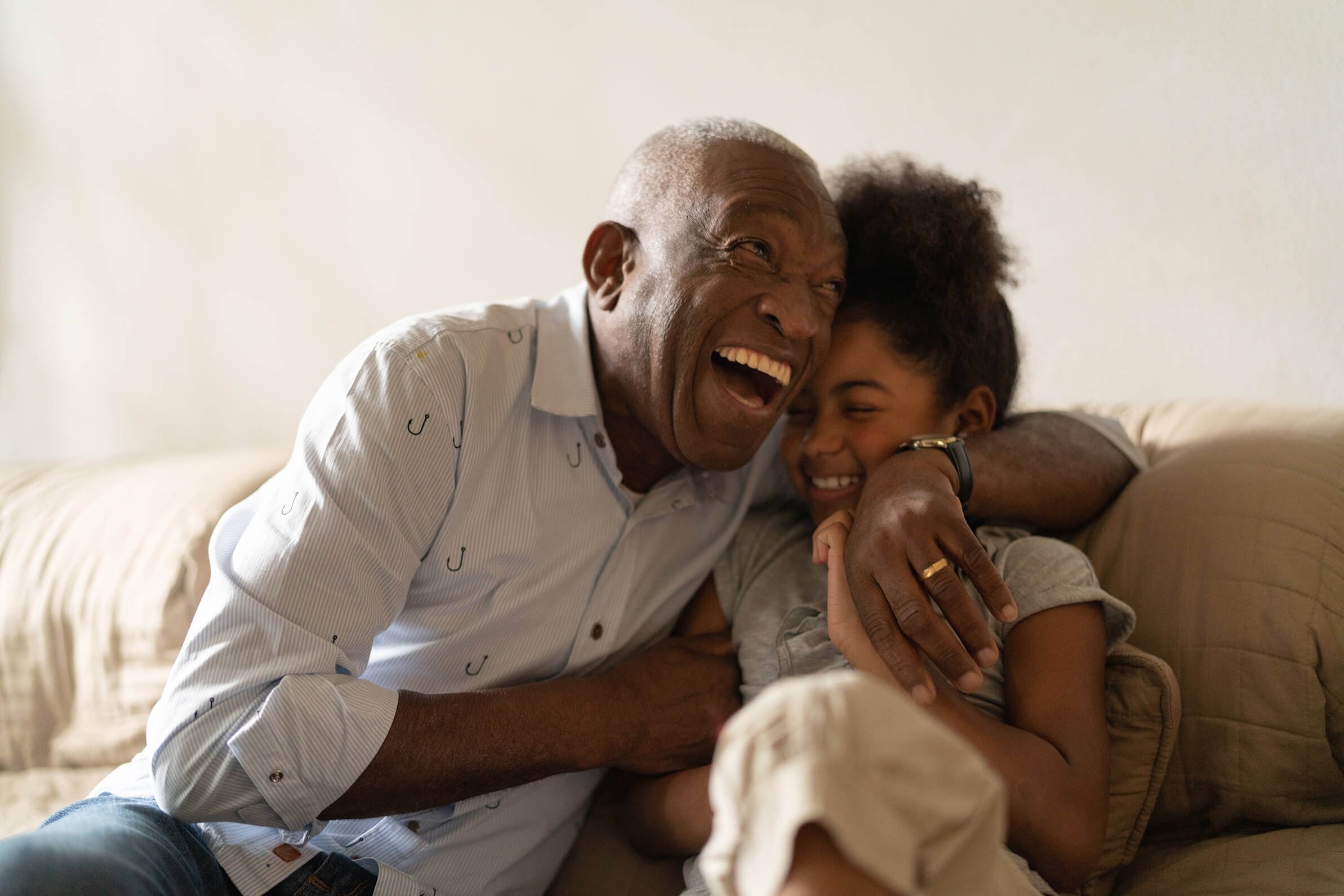 grandad hugging his grandchild smiling